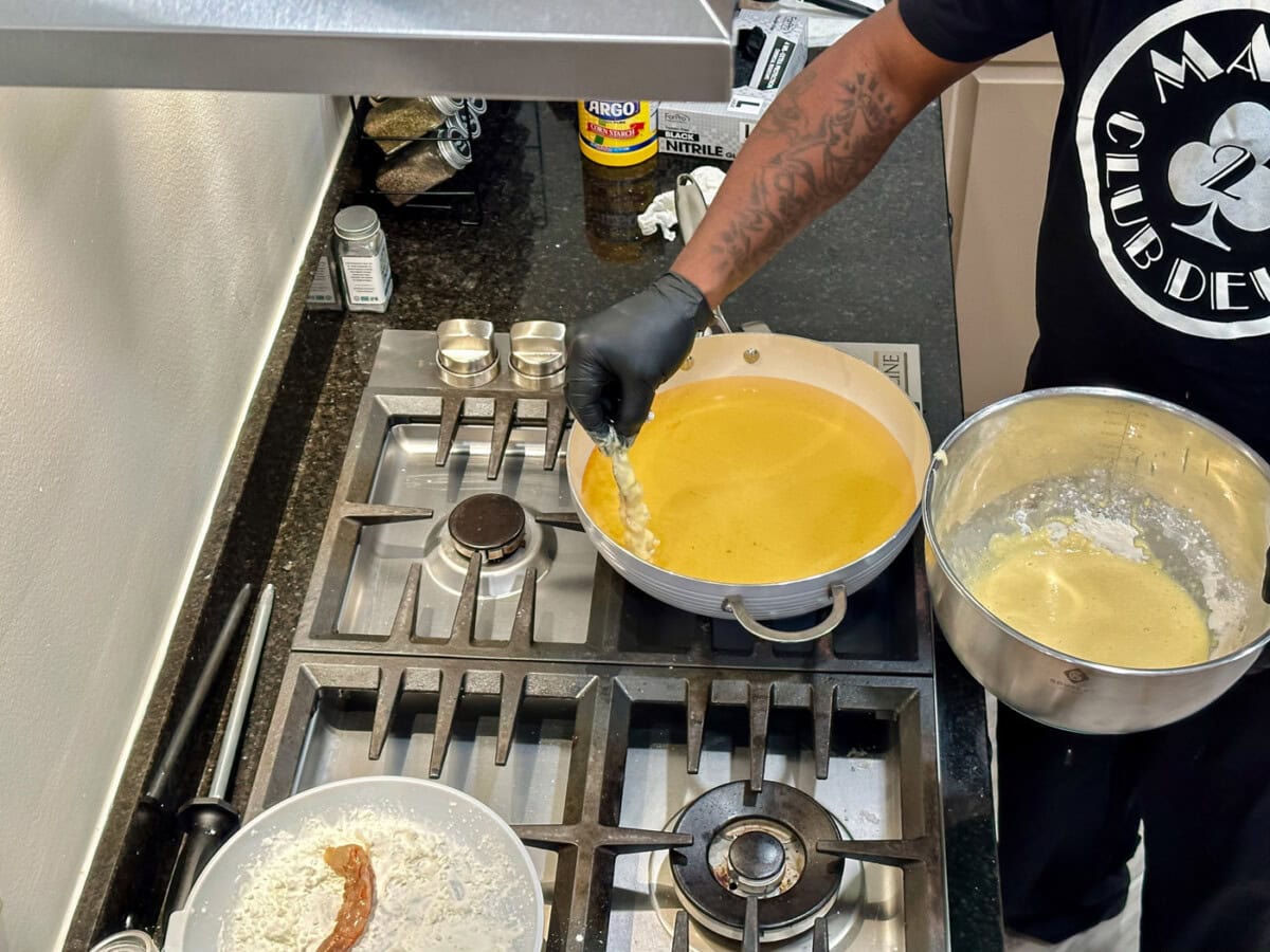 placing battered shrimp into hot oil