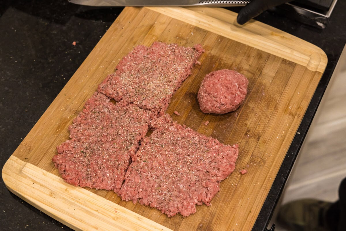 rolling burger meat on a cutting board