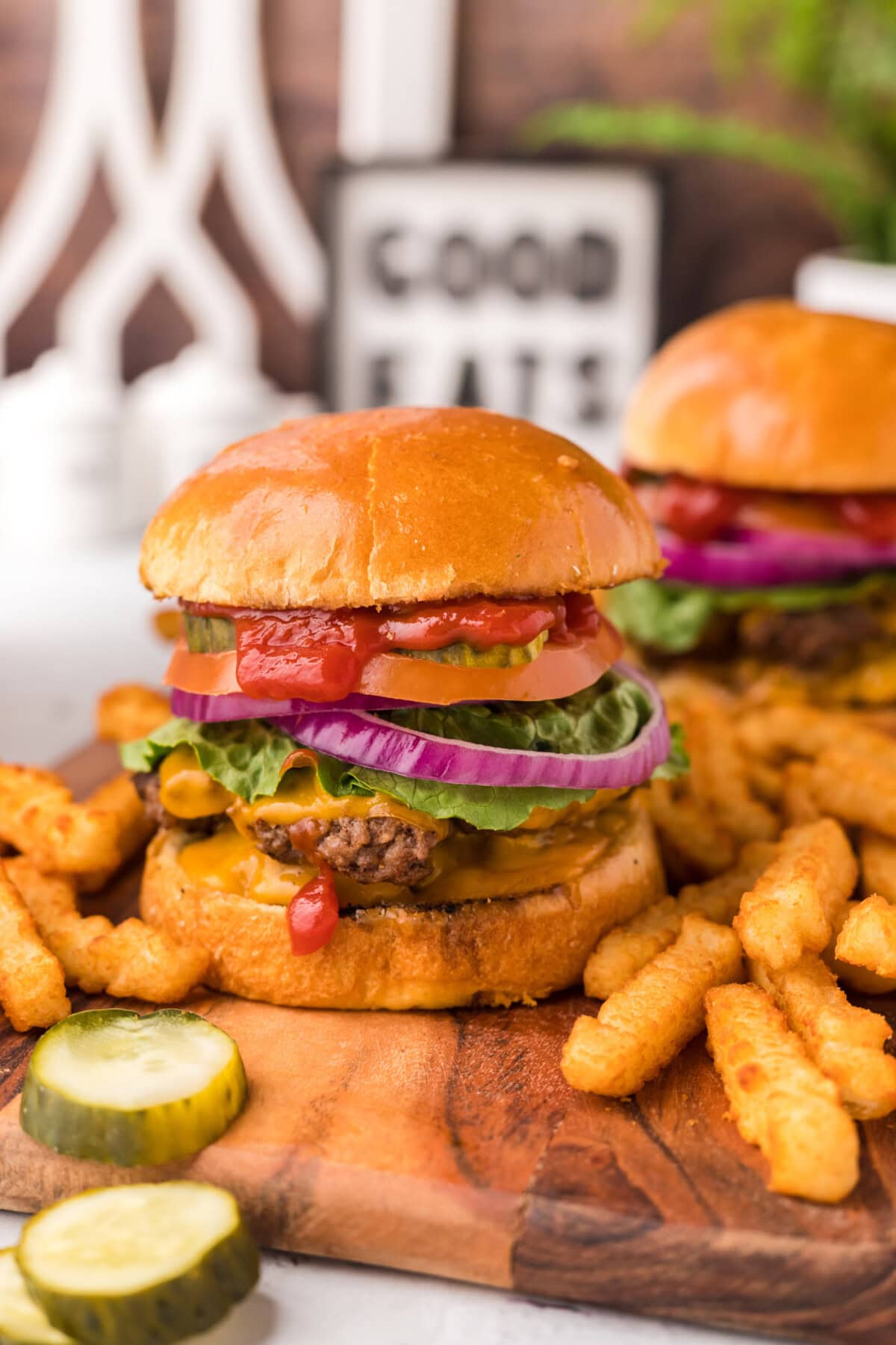 Smash Burger on a platter with pickles and french fries on the side