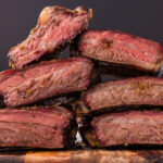 Close up photo of Smoked Beef Ribs stacked on a wooden platter