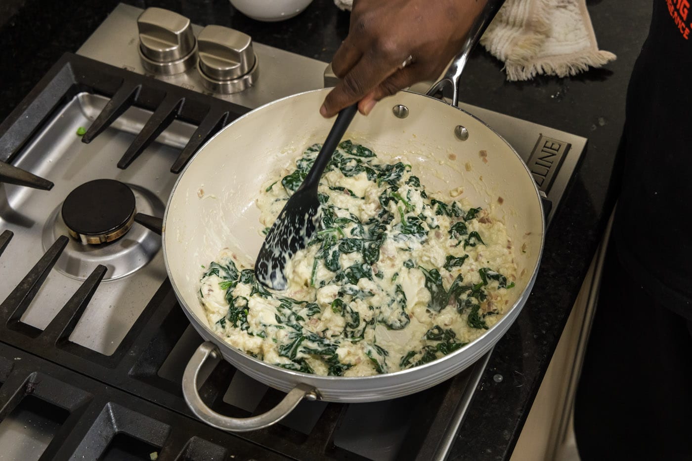 stirring cream cheese spinach mixture in a skillet