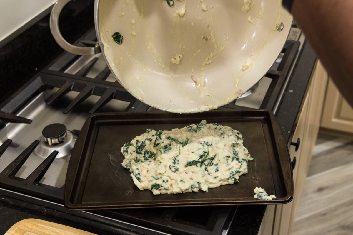 pouring salmon stuffing onto a baking sheet