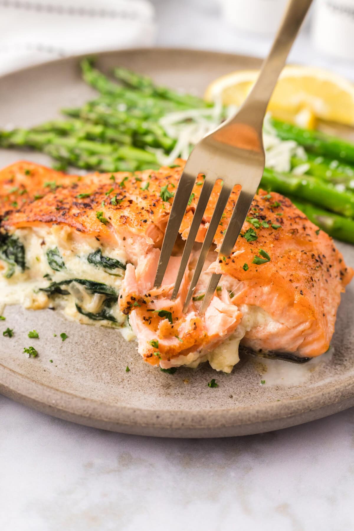 Fork breaking a piece of Stuffed Salmon off the filet