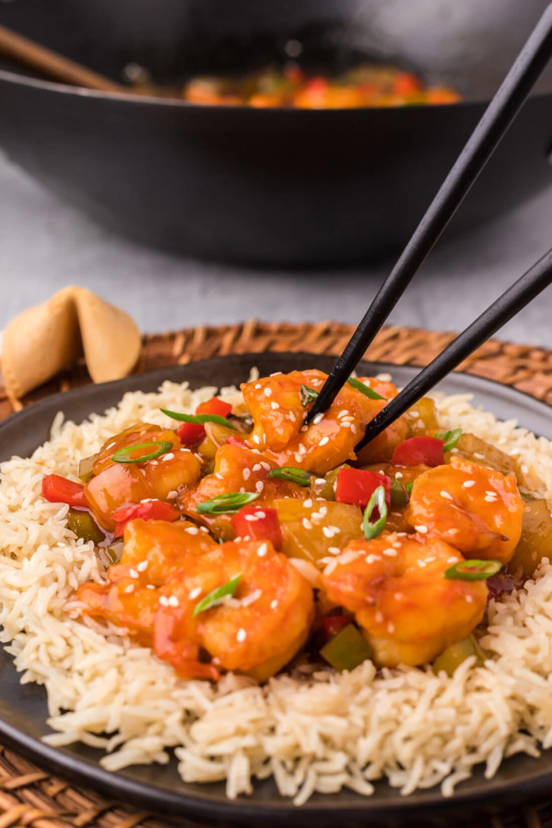 Sweet and Sour Shrimp on a plate served over rice with chopsticks