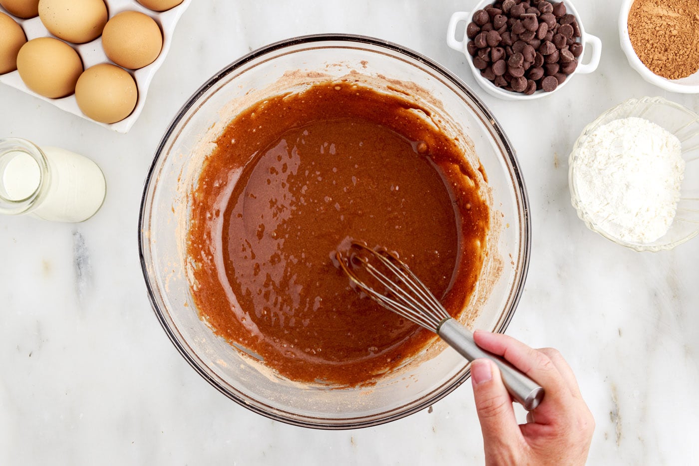 whisking chocolate cake batter in a bowl