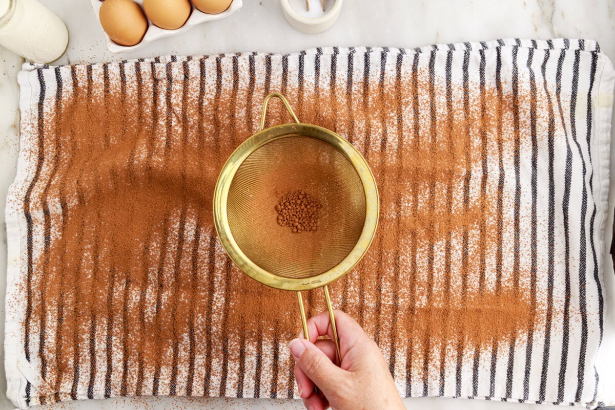 sifting cocoa powder over a tea towel