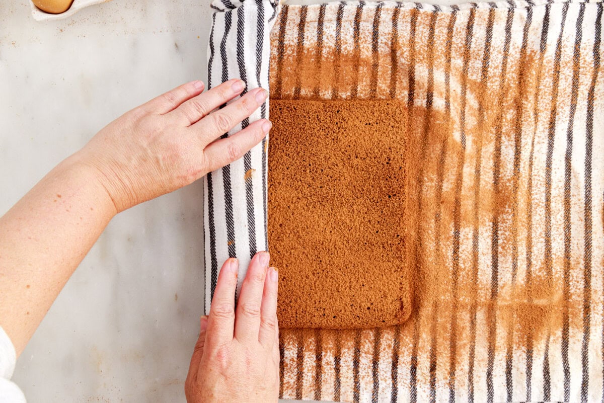 rolling swiss roll cake with a tea towel