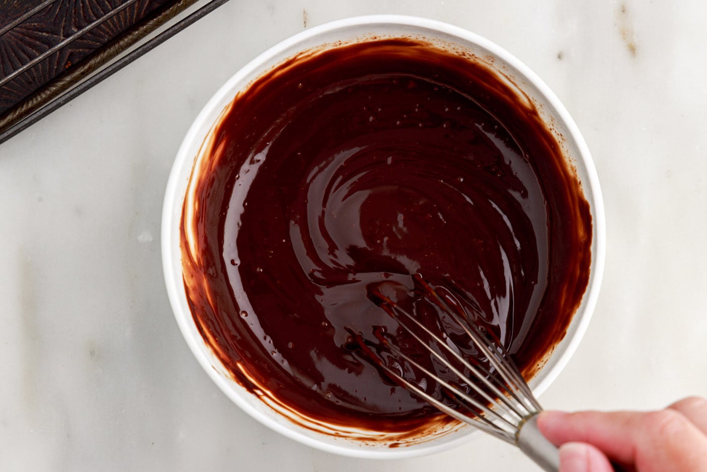 chocolate ganache in a bowl with a whisk