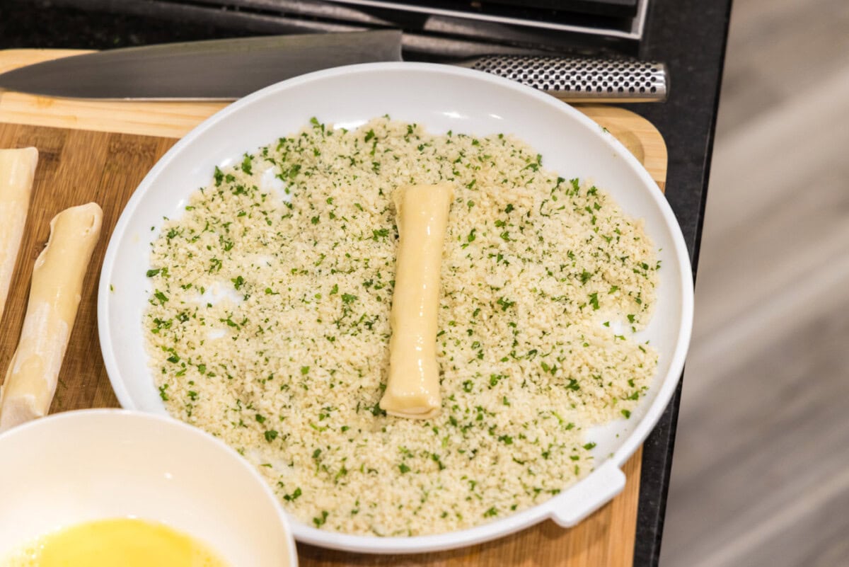 rolling mozzarella sticks in panko breadcrumbs