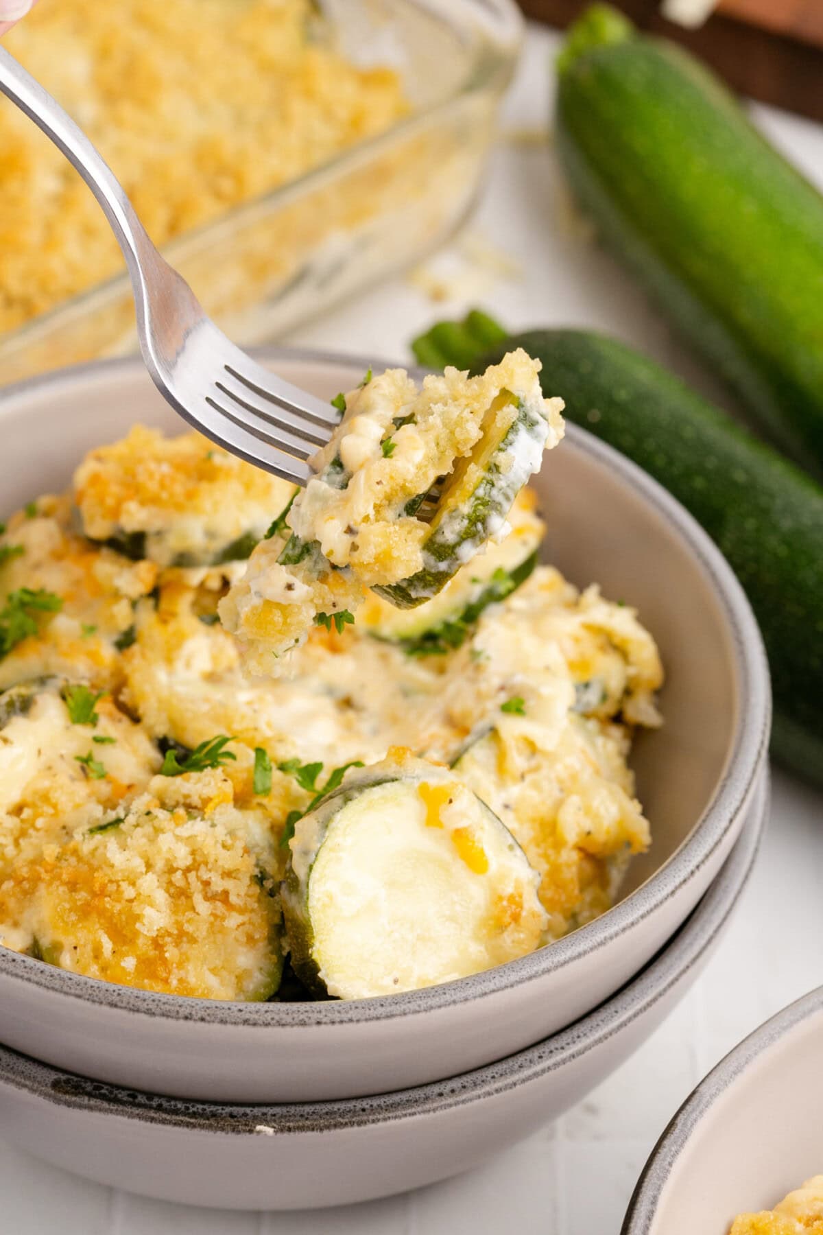 Zucchini Casserole on a fork being lifted out of a bowl of Zucchini Casserole