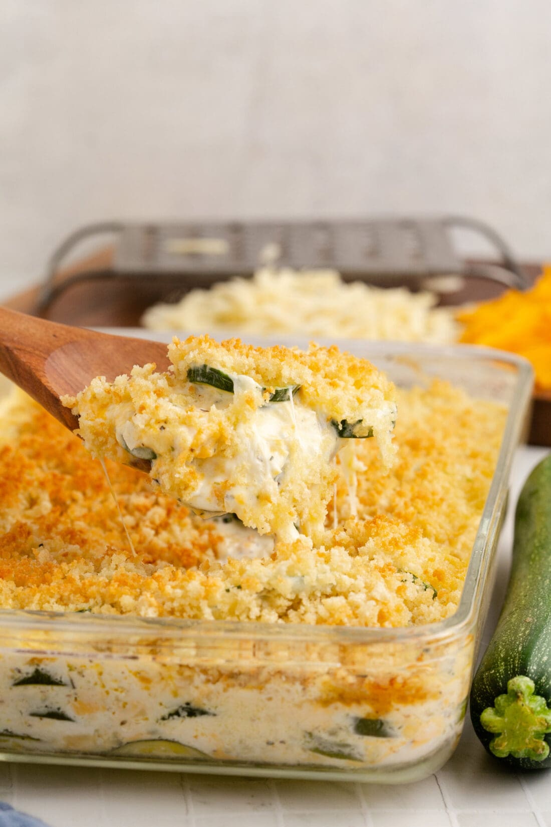 Zucchini Casserole on a spoon being lifted out of a pan of Zucchini Casserole
