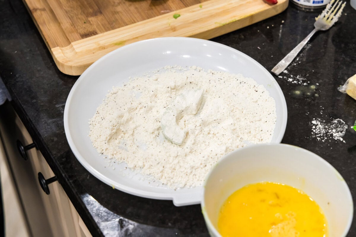 dredging avocado slice in flour