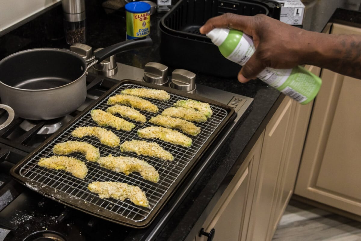 spraying cooking spray on avocado fries