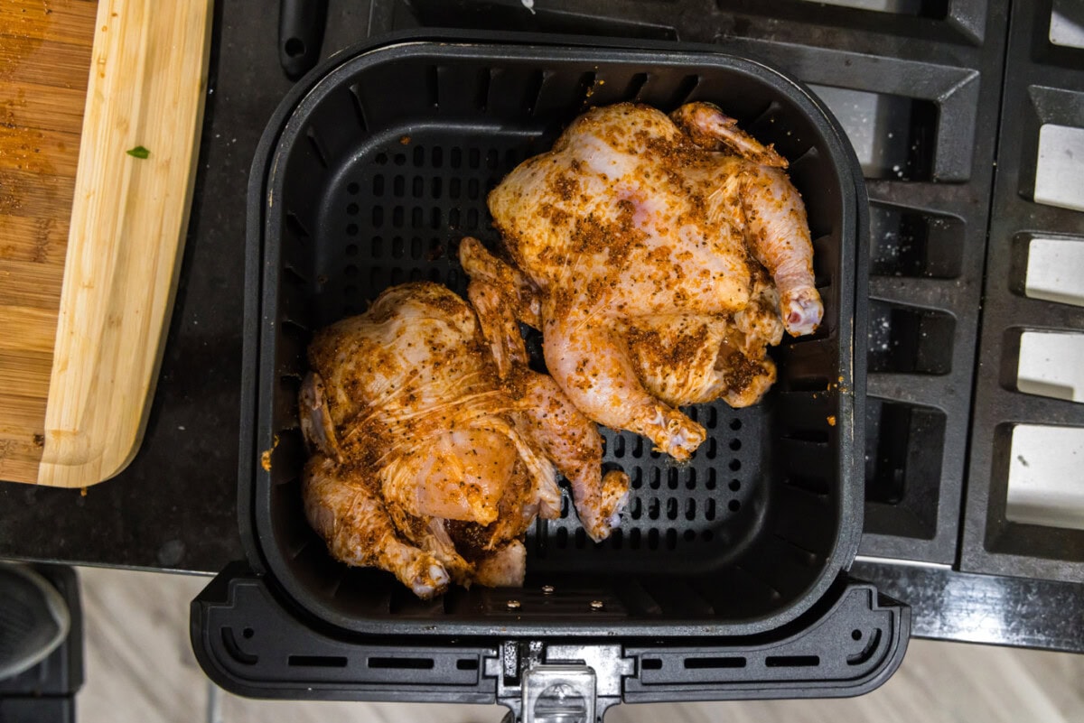 two cornish hens in an air fryer basket
