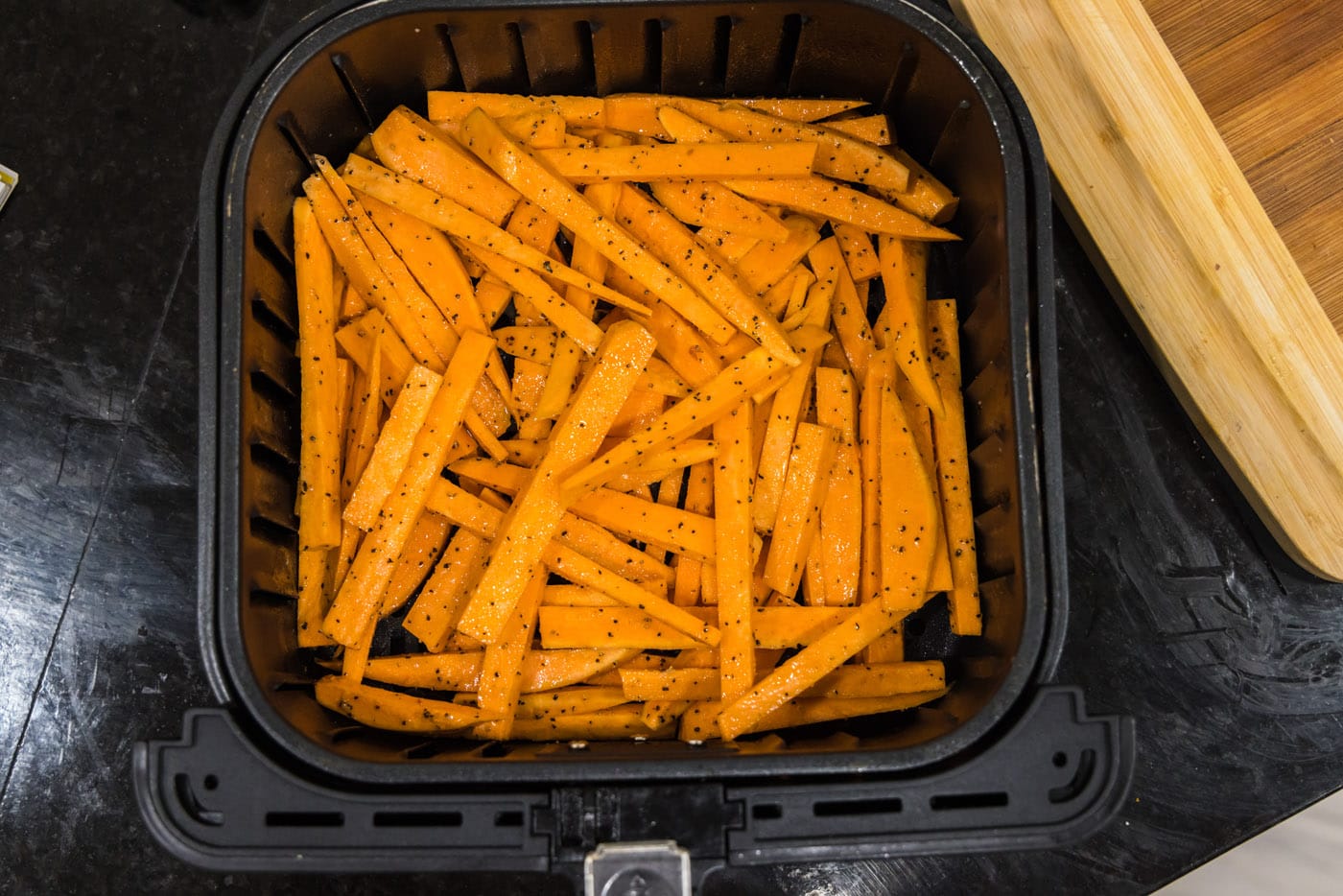 sweet potato fries in an air fryer basket