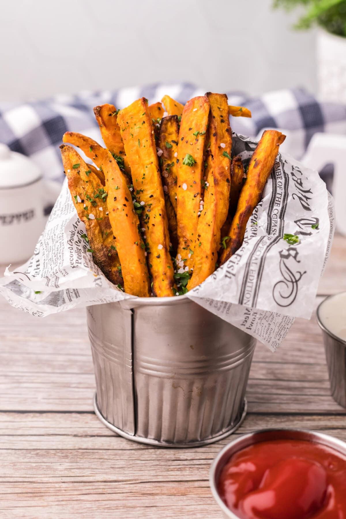 Air Fryer Sweet Potato Fries in a metal fry cup with parchment paper