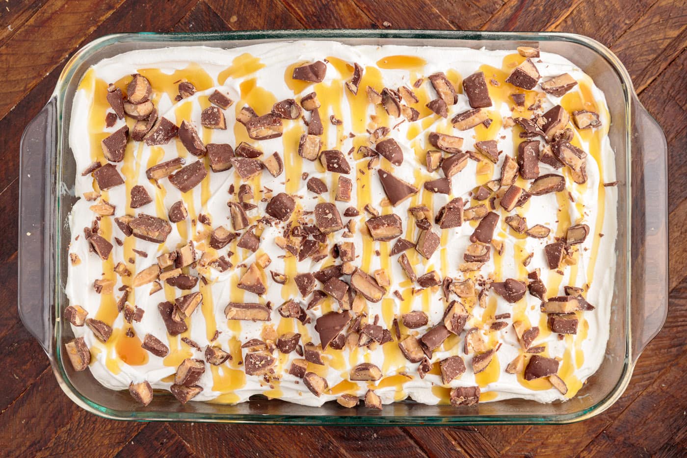 caramel and chopped toffee bits over poke cake