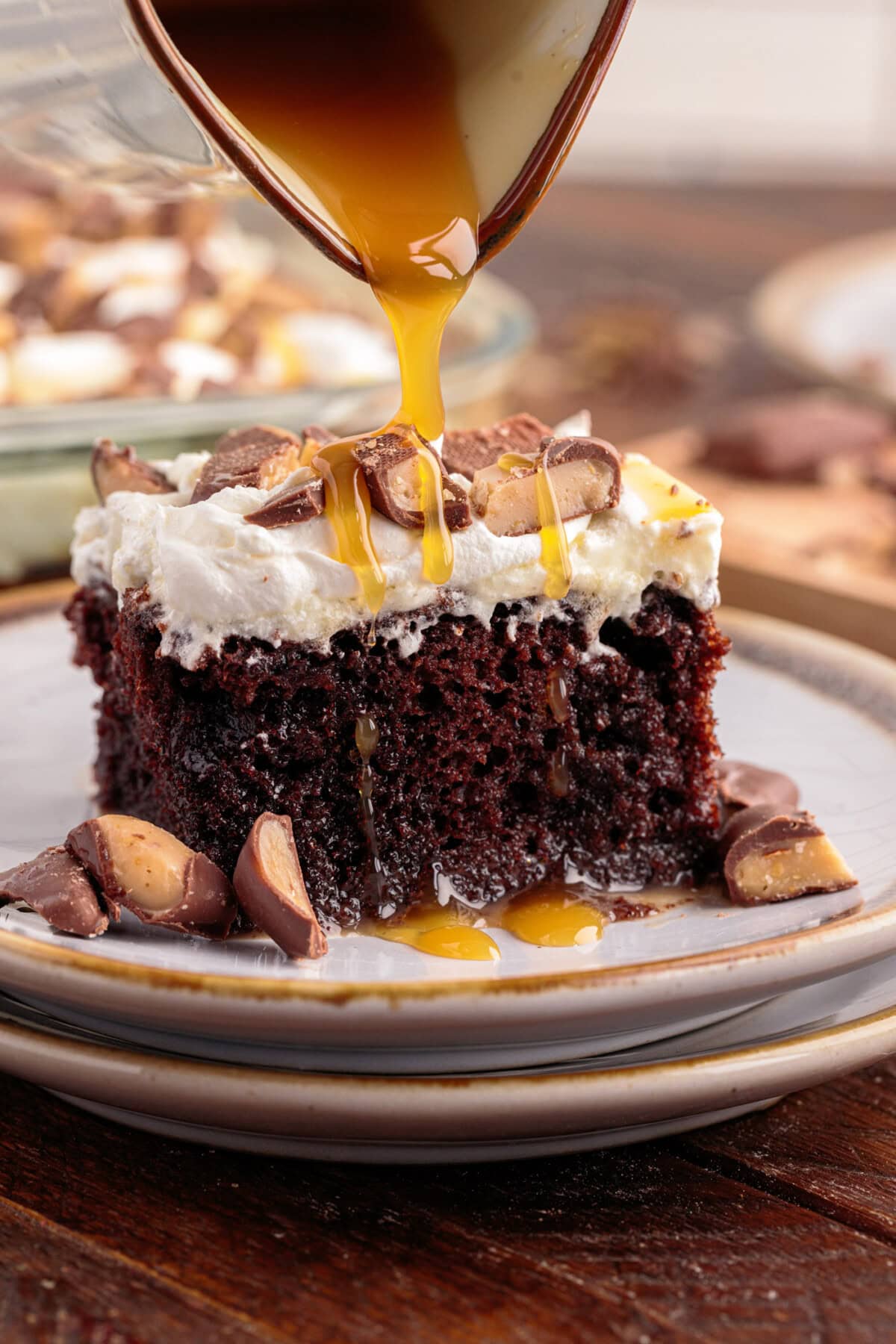 Caramel being drizzled over a piece of Better Than Sex Cake