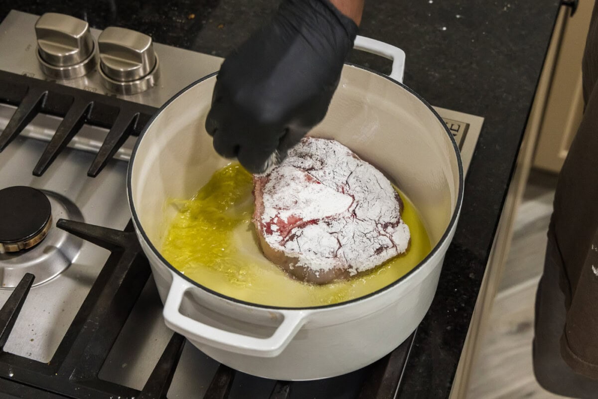 adding cornstarch coated beef shanks to hot oil