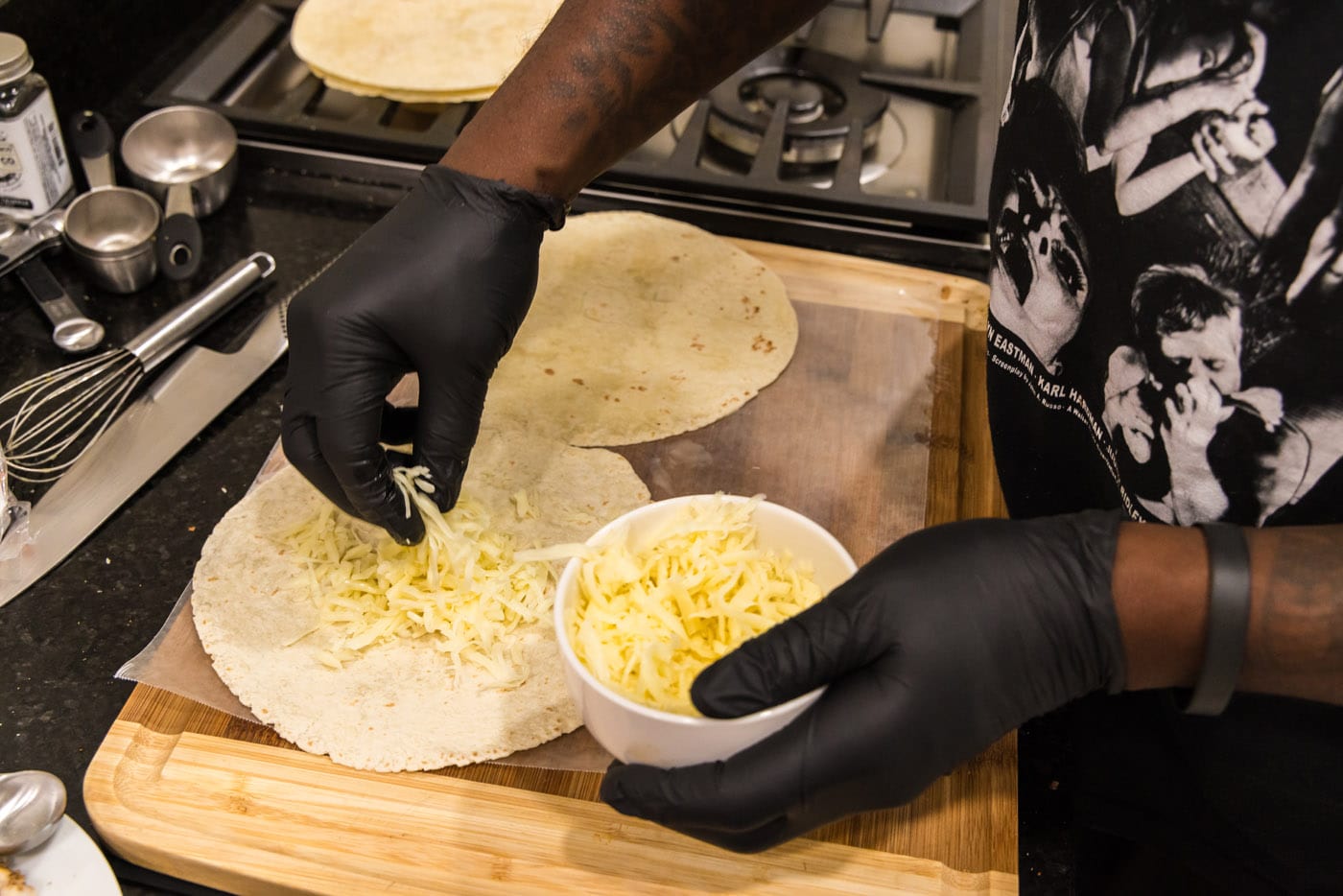 adding shredded cheese to tortillas