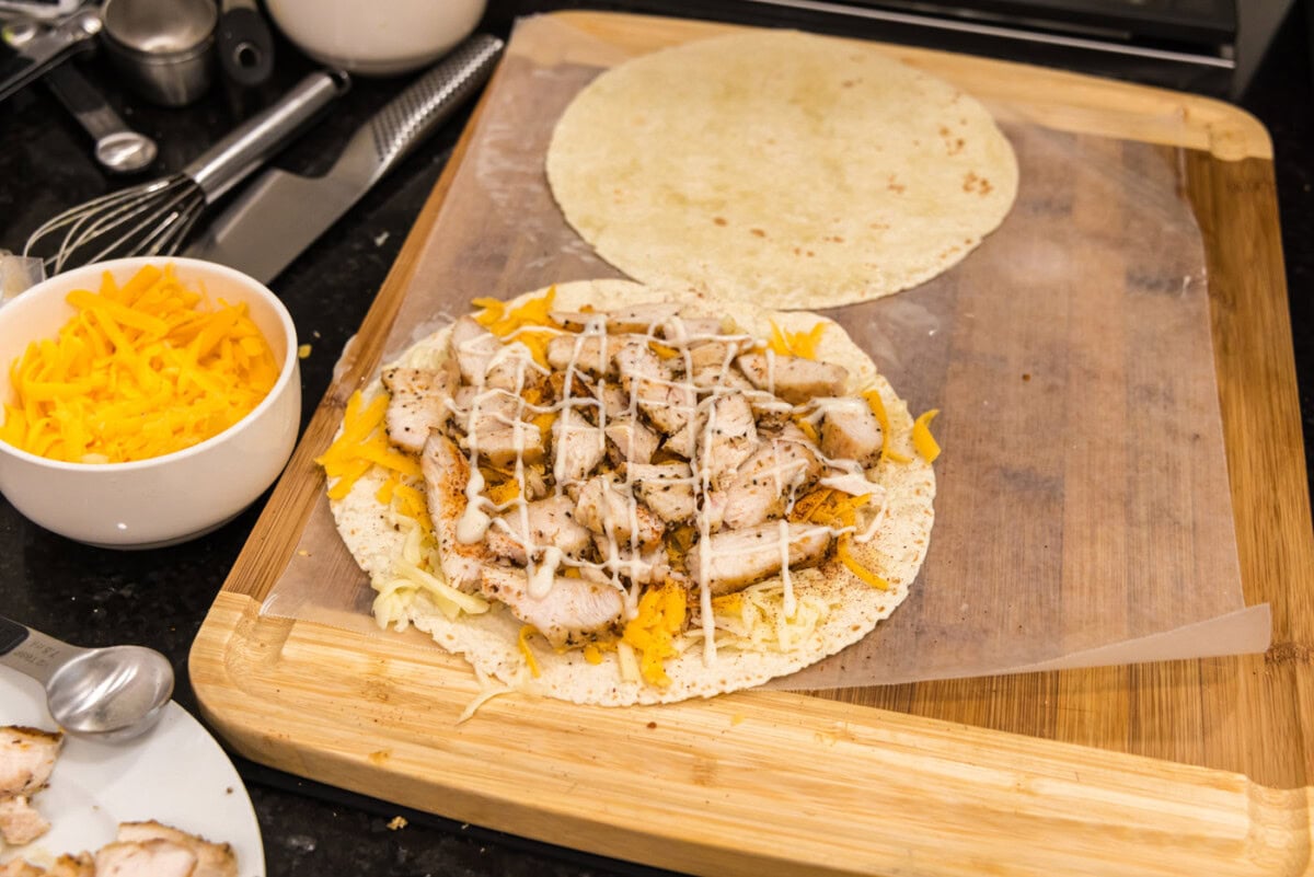 ranch dressing drizzled over chicken and cheese tortilla shell
