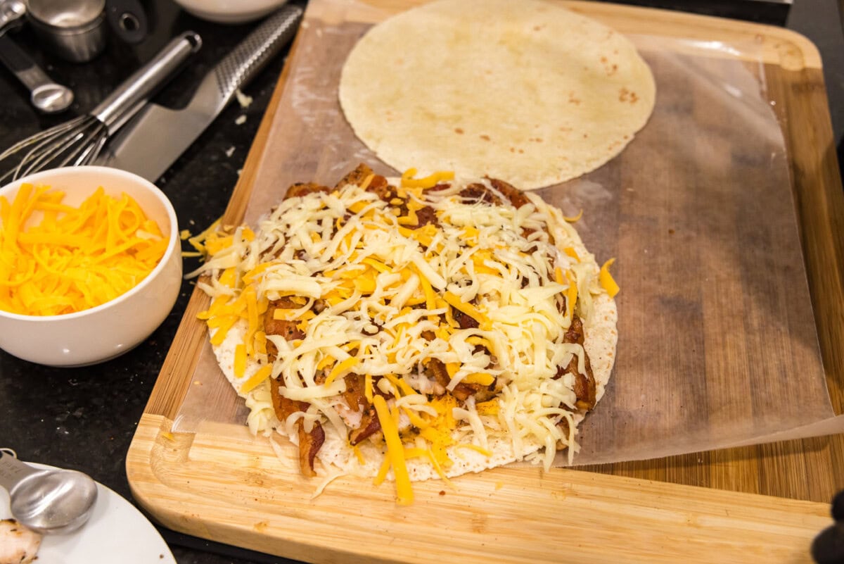 shredded cheese over the top of bacon, ranch, and chicken tortilla
