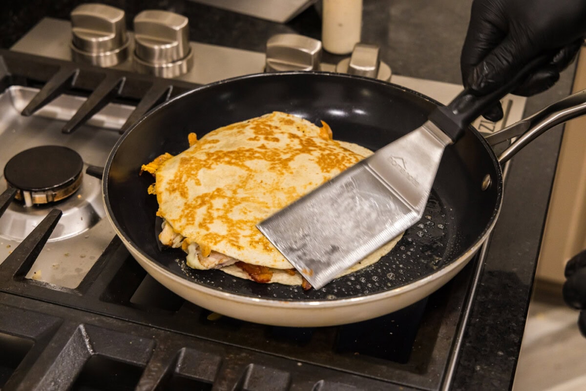 fish turner spatula flipping chicken bacon ranch quesadilla in a skillet