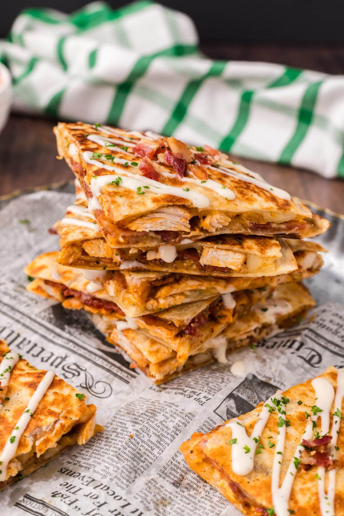 Stack of Chicken Bacon Ranch Quesadillas topped with ranch dressing