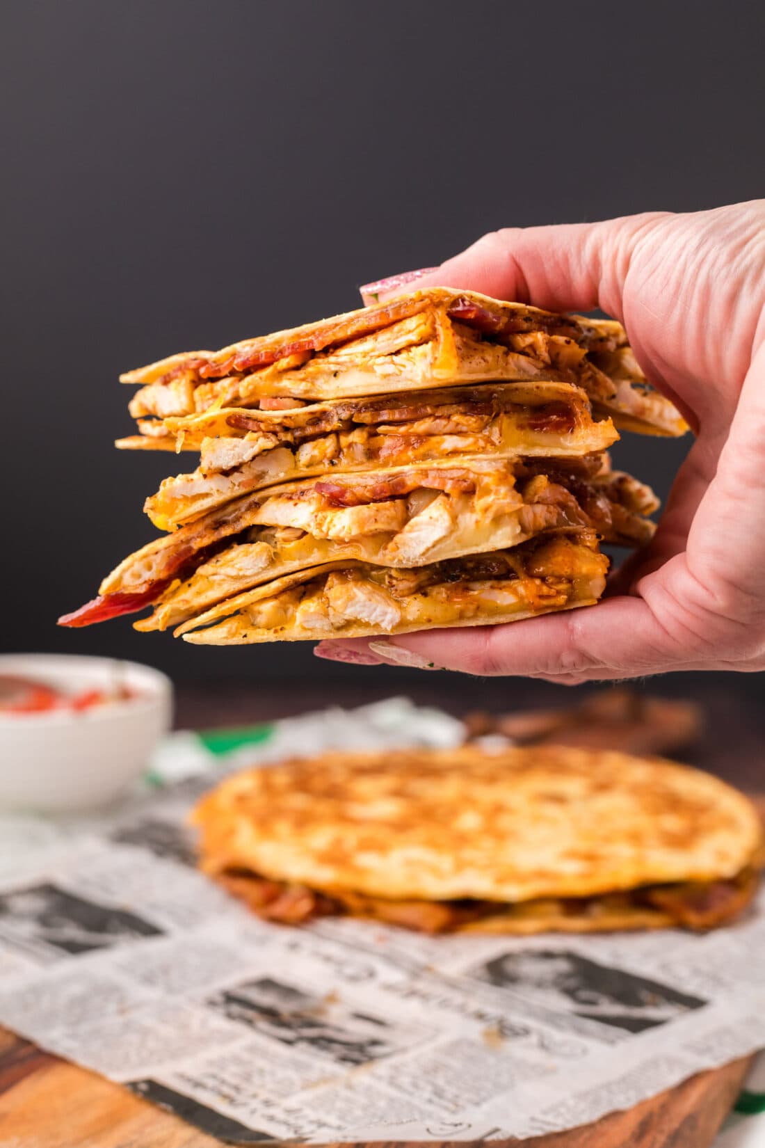 Hand holding up a stack of Chicken Bacon Ranch Quesadillas