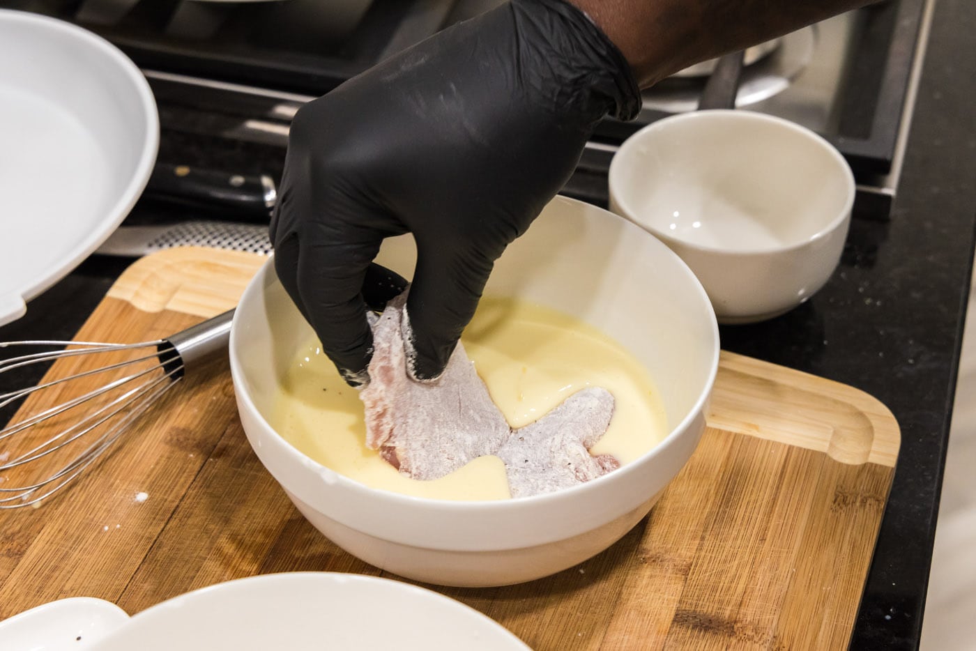 dipping flour coated chicken into egg mixture