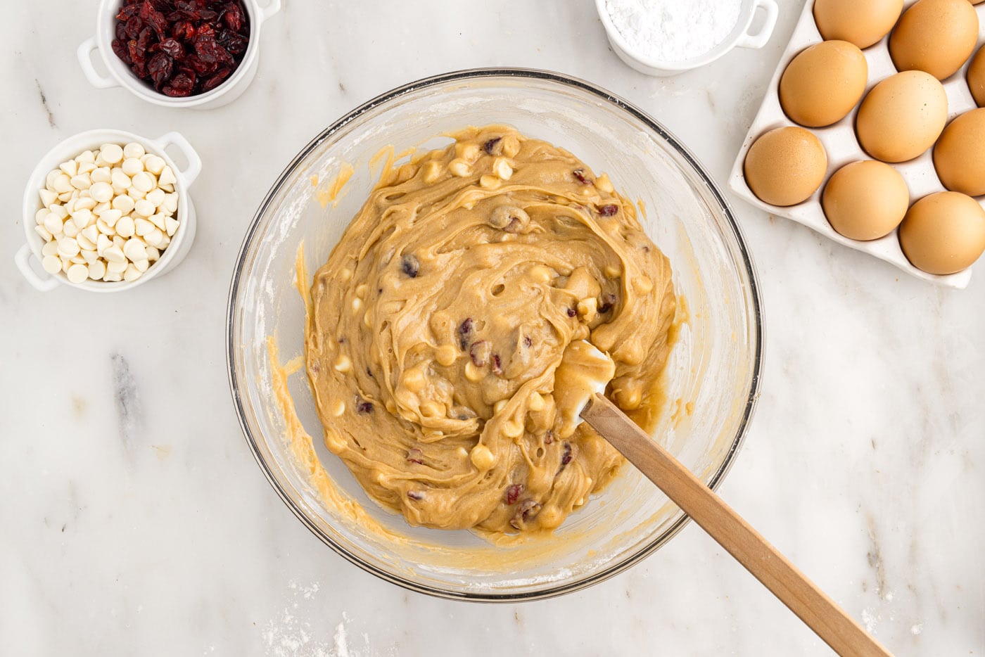 blondie dough with white chocolate chips and dried cranberries in a bowl