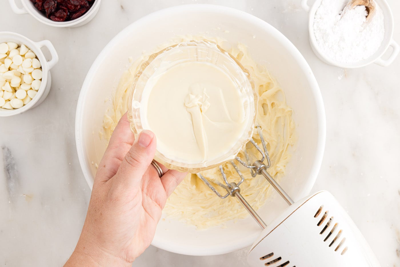 adding melted white chocolate to cream cheese frosting