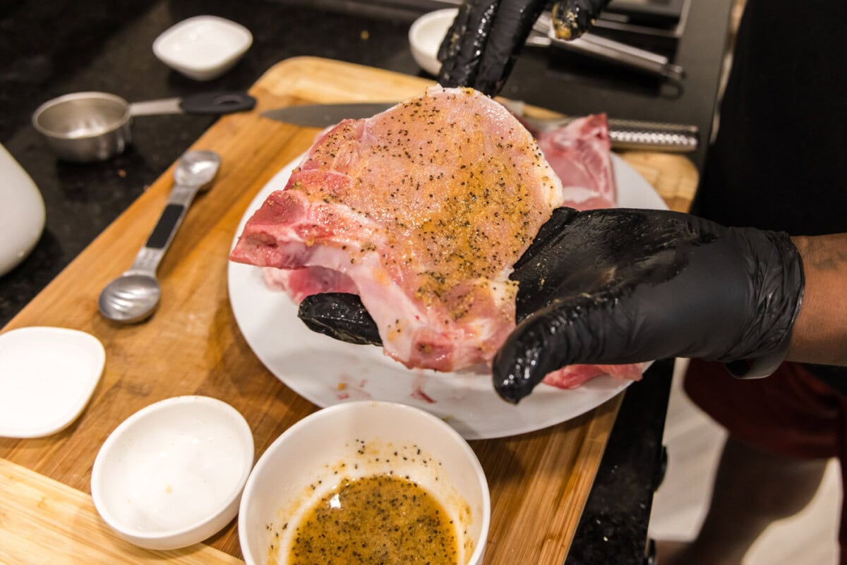adding seasoning to pork chops