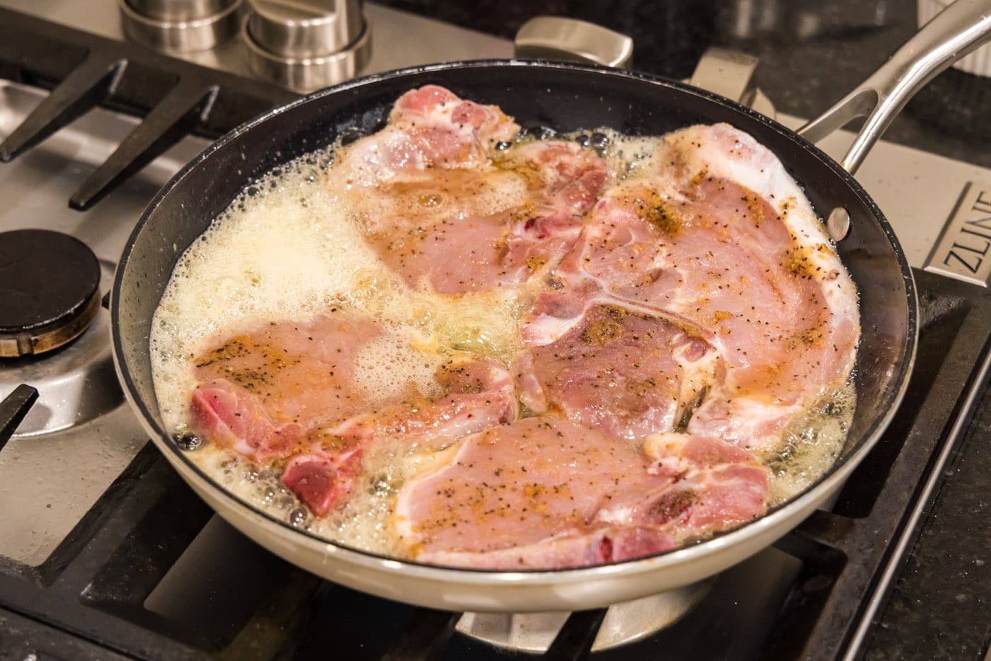 cooking pork chops in a skillet with butter and oil