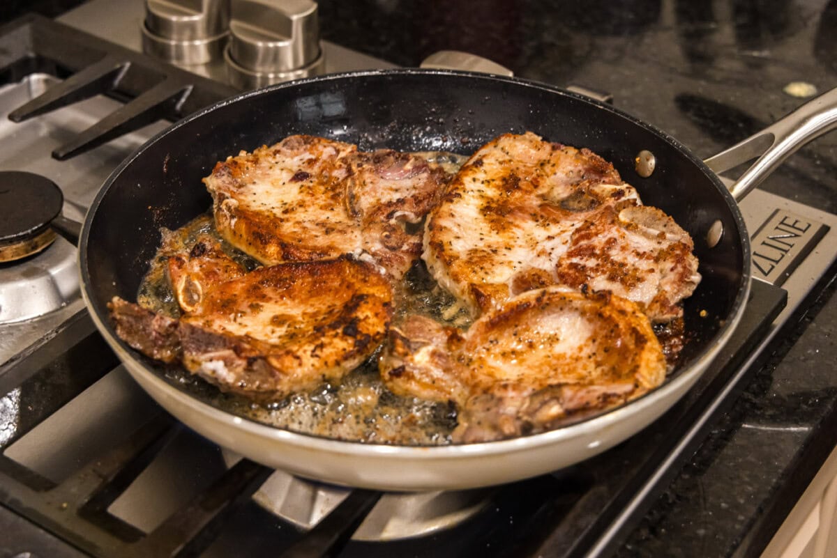 seared pork chops in a skillet