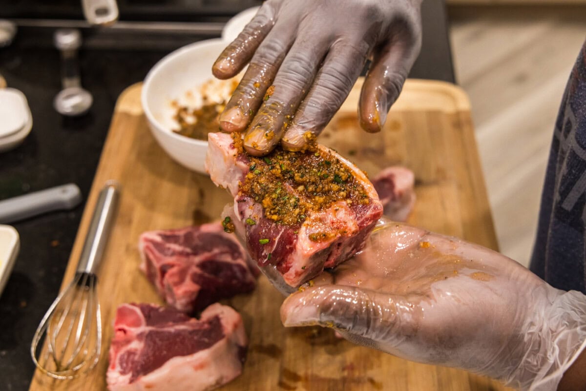 hand rubbing wet rub over lamb loin chops