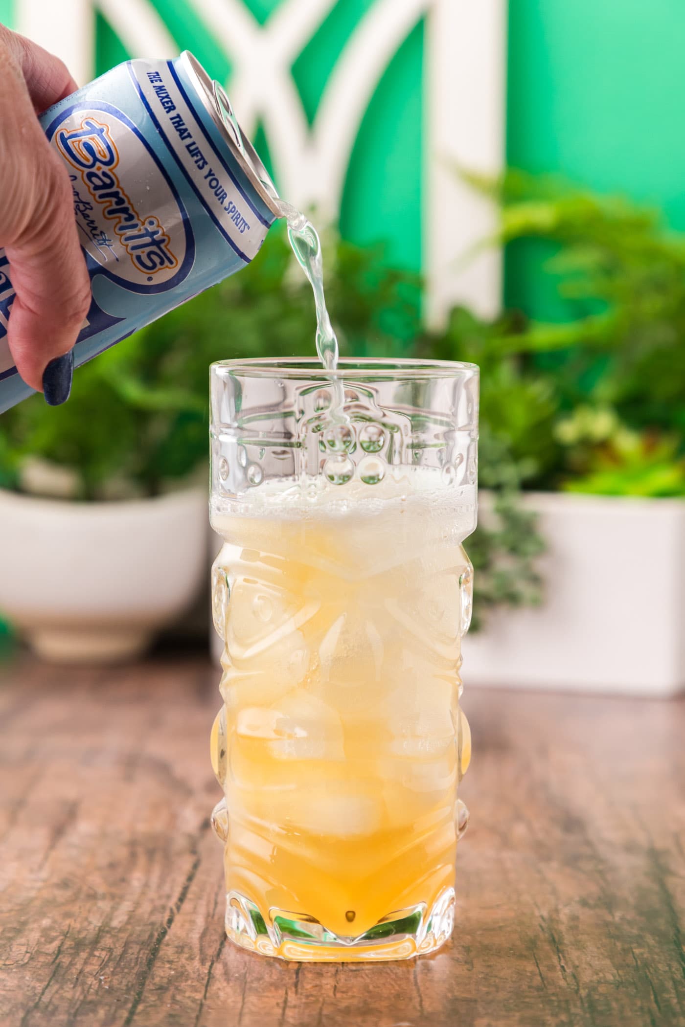 pouring ginger beer over rum and lime juice