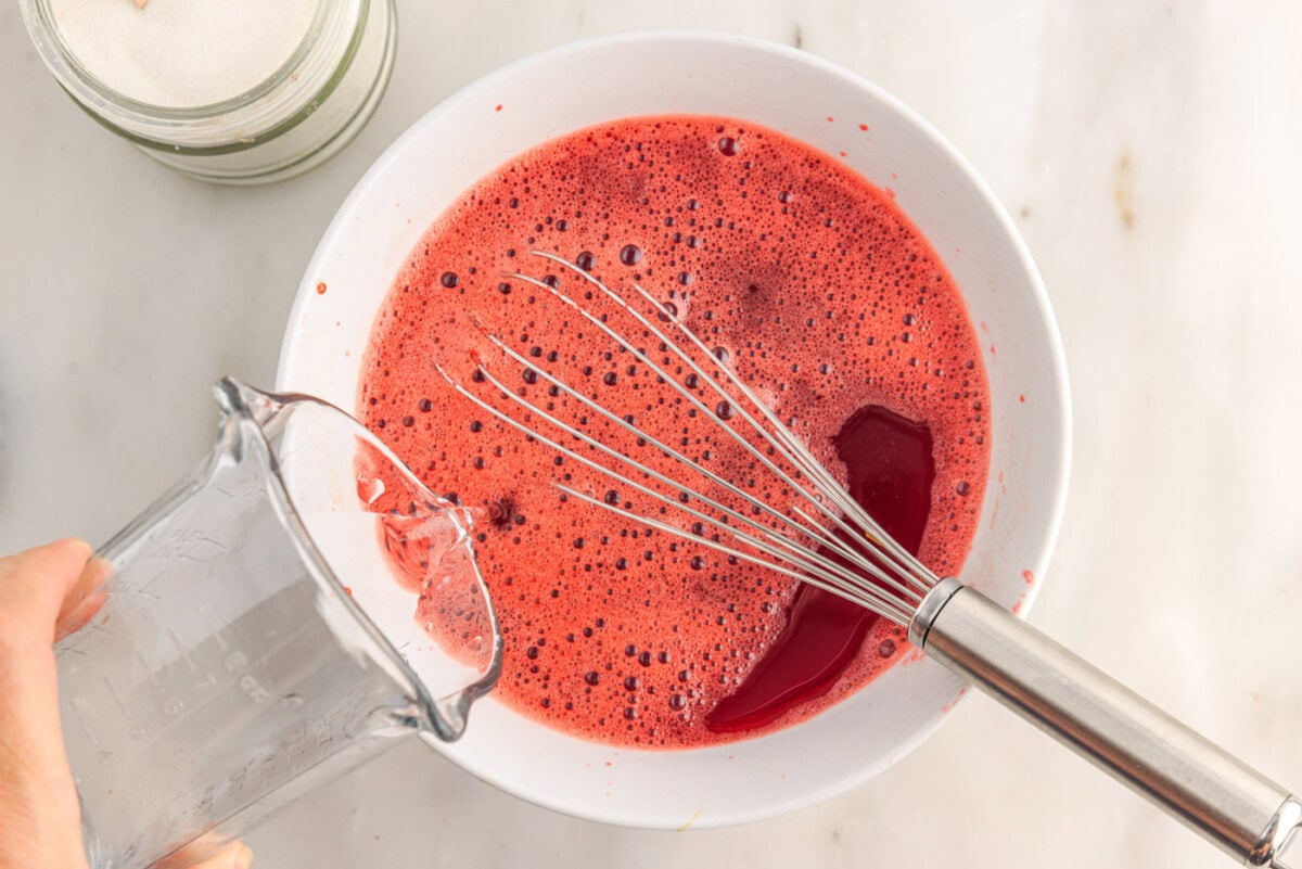 pouring cold water into jello mixture