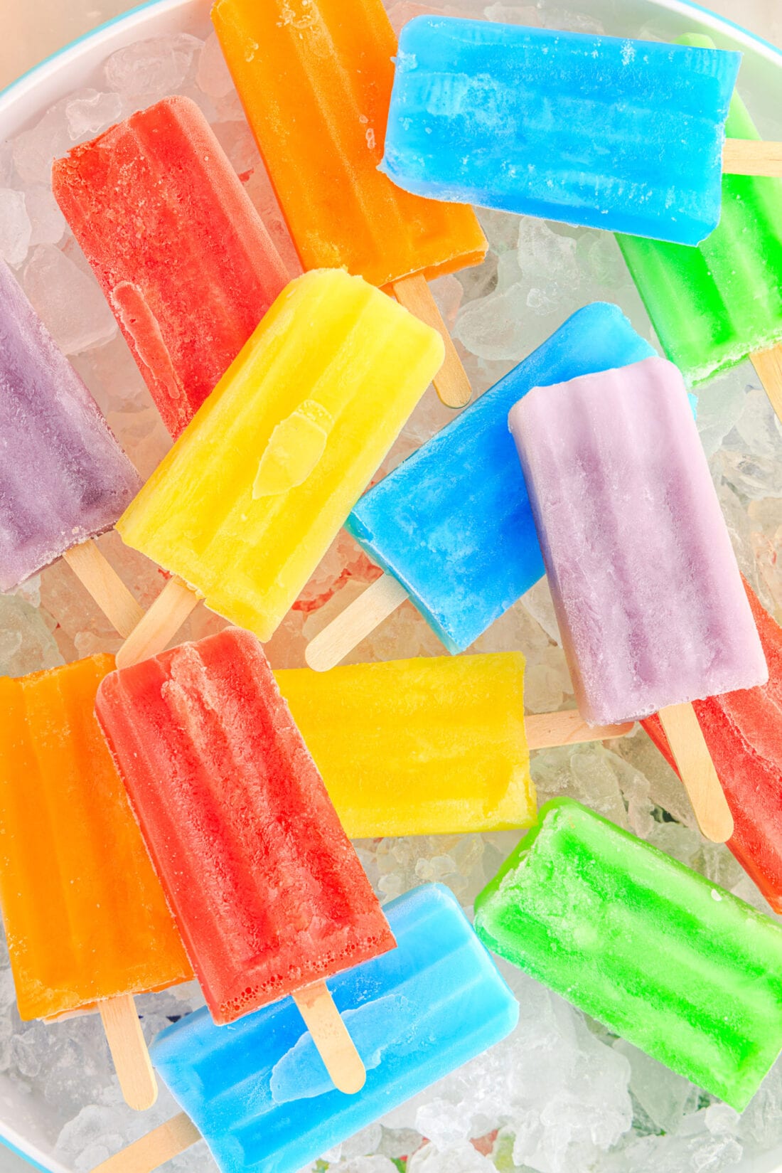 Close up photo of an assortment of Jello Popsicles resting over a bowl of ice