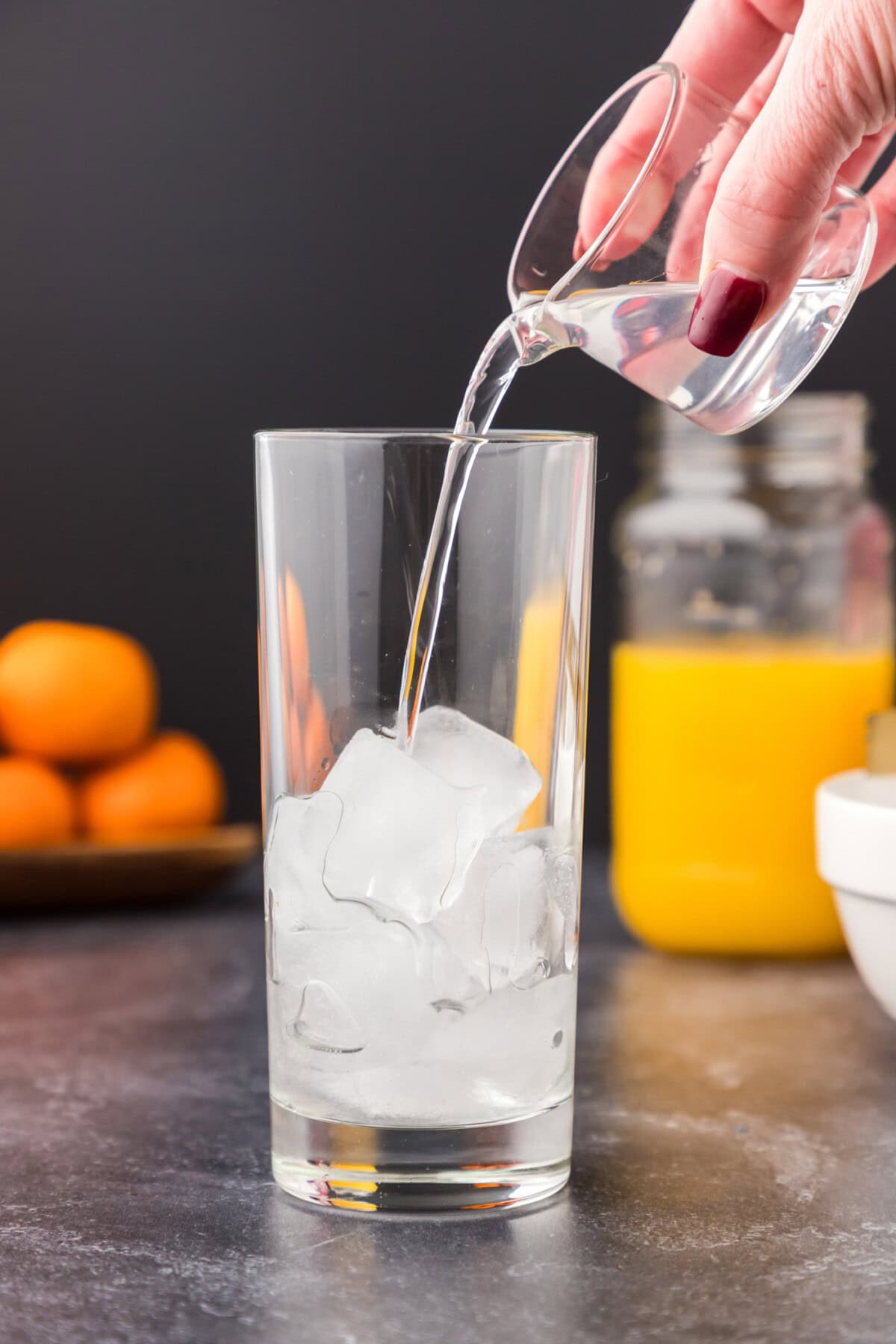 pouring coconut rum into glass of ice