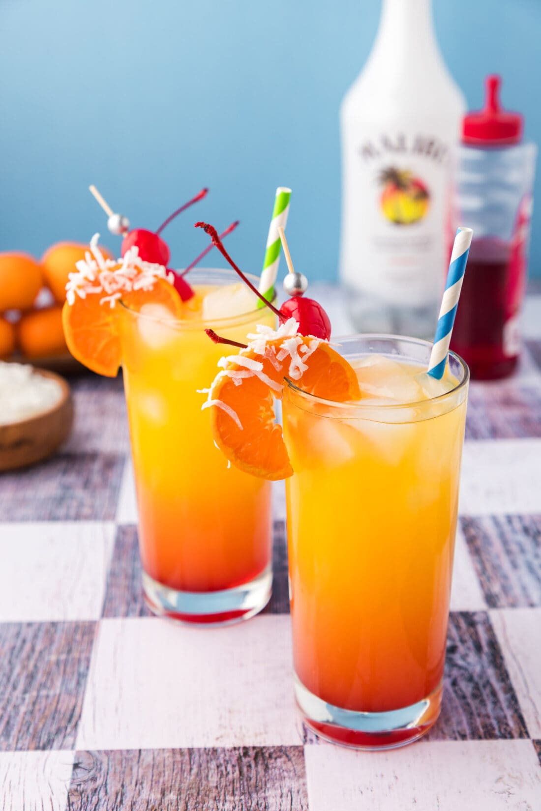 Two Malibu Sunrise topped with an orange wheel and cherry.