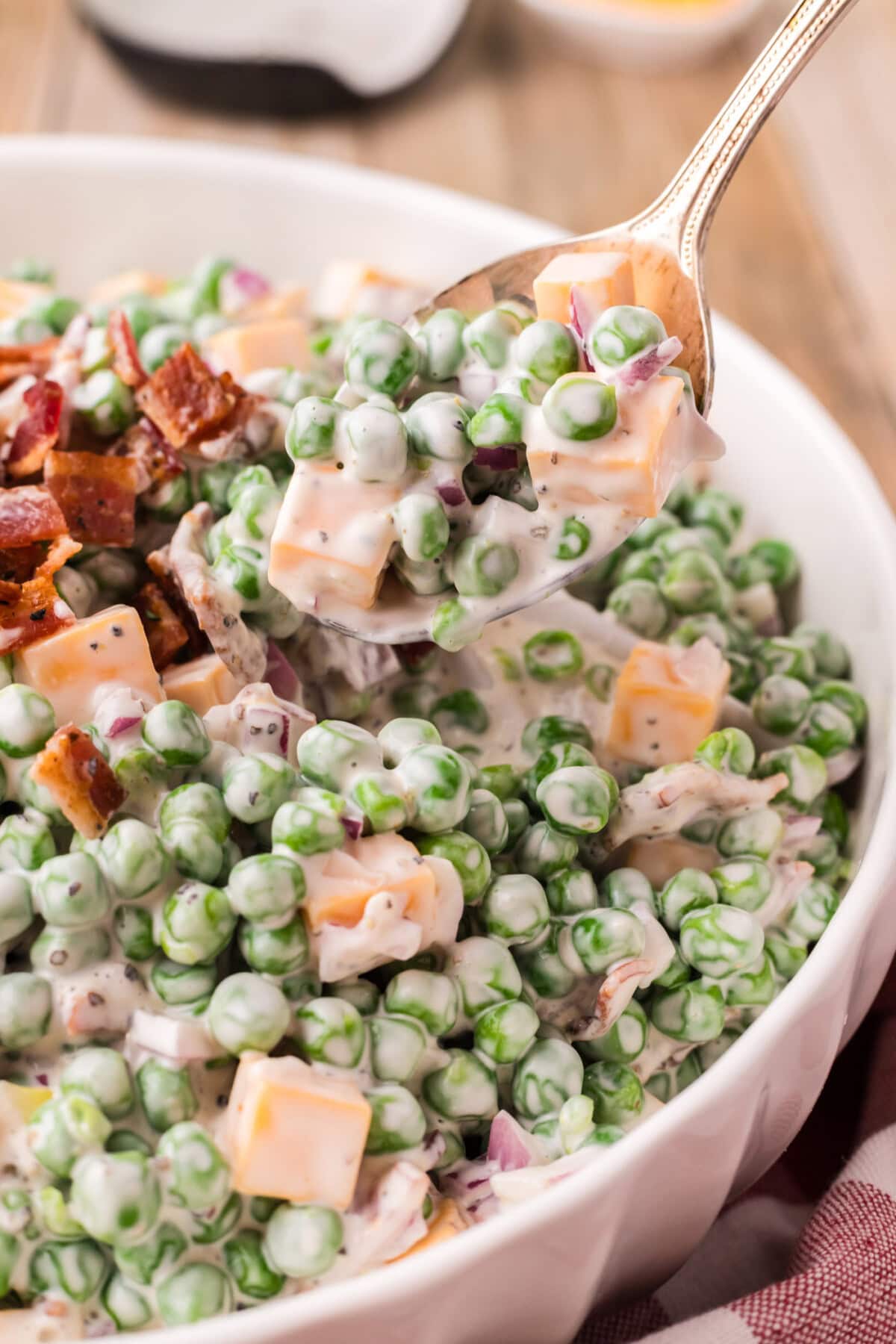 Spoonful of Pea Salad being lifted out of a bowl of Pea Salad