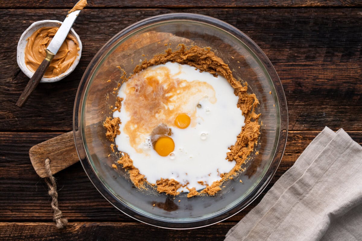 eggs, milk, and vanilla added to peanut butter mixture in a bowl