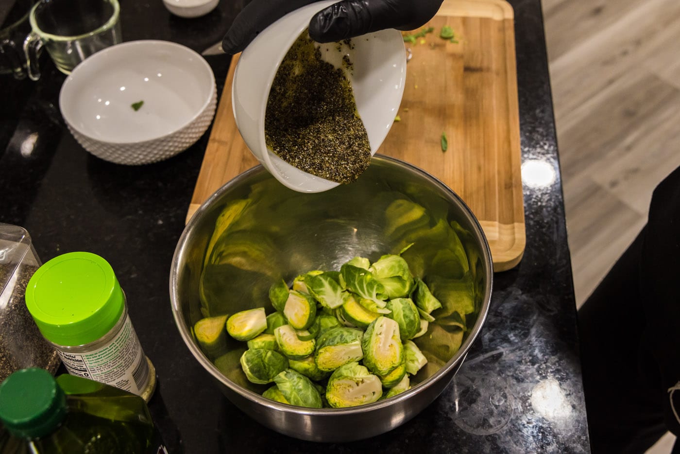 pouring olive oil mixture over brussels sprouts