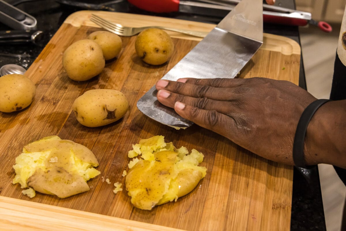 smashing yukon gold potatoes with a spatula