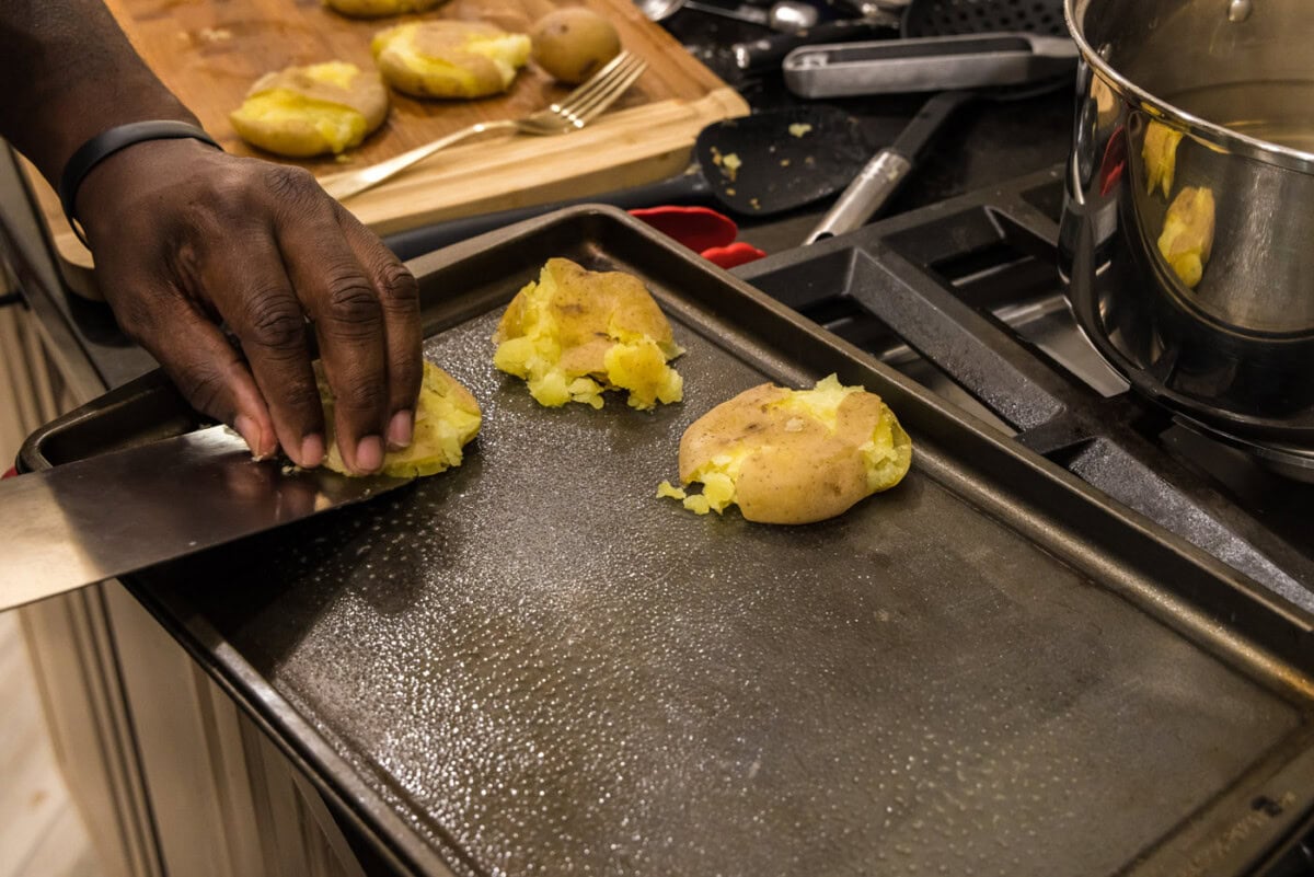 placing potatoes onto a baking sheet