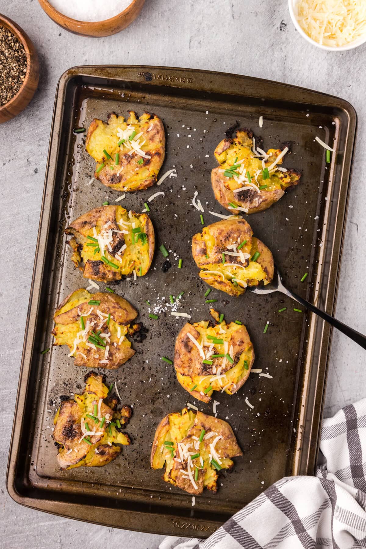 Smashed Potatoes on a sheet pan with a serving fork
