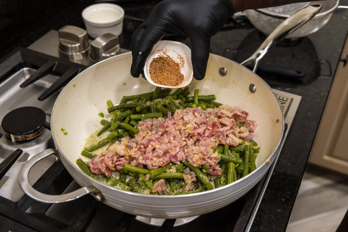 adding cajun seasoning to southern green beans