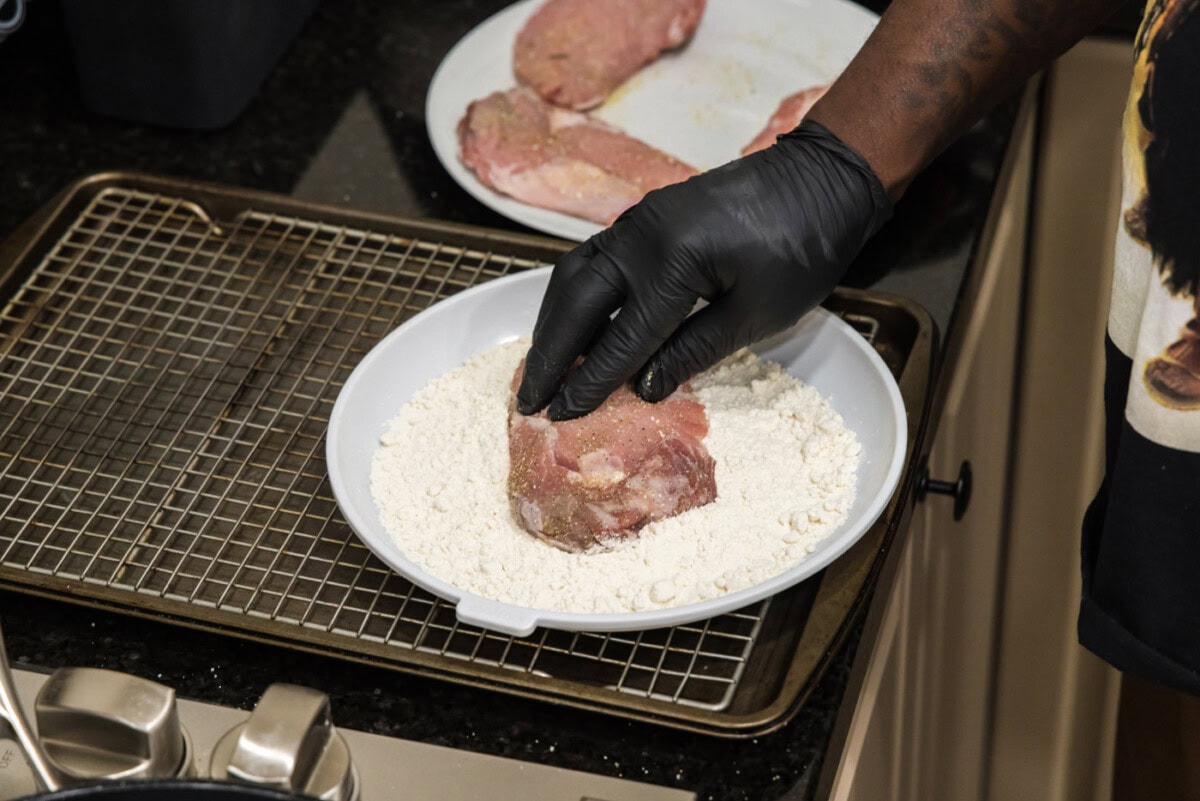 pressing veal chop into flour