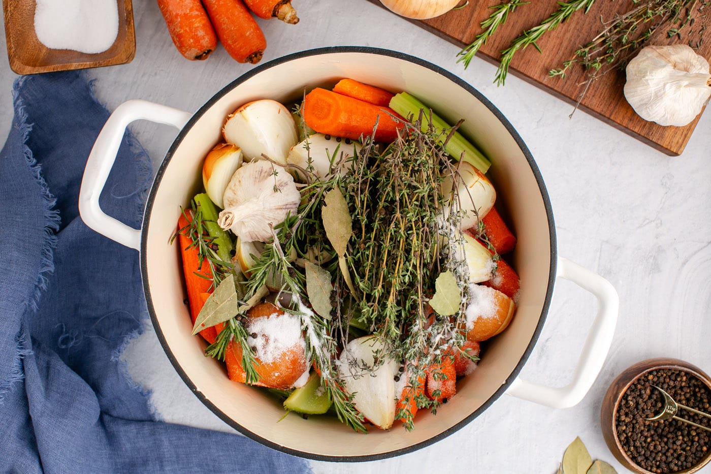 fresh herbs on top of vegetables in a stockpot
